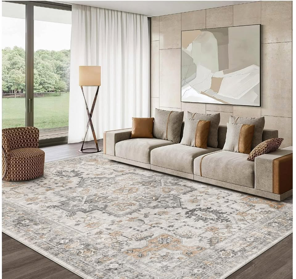 Modern living room with a beige sofa, patterned rug, and abstract painting.