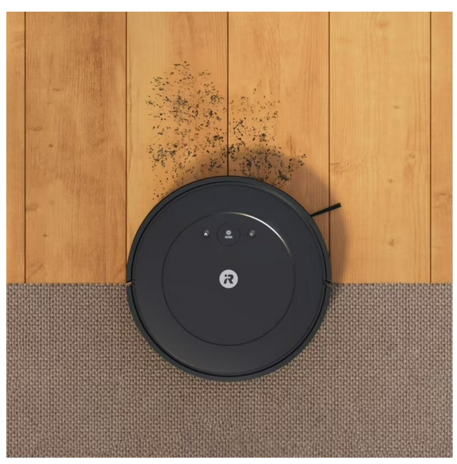 Robot vacuum cleaner on a wooden floor with dust particles