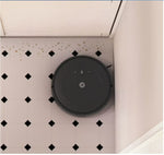 Robot vacuum cleaner on a tiled floor with dirt particles visible