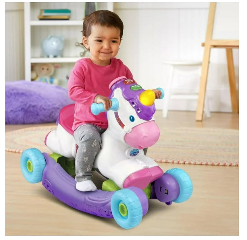 Child playing with a colorful toy unicorn in a room.