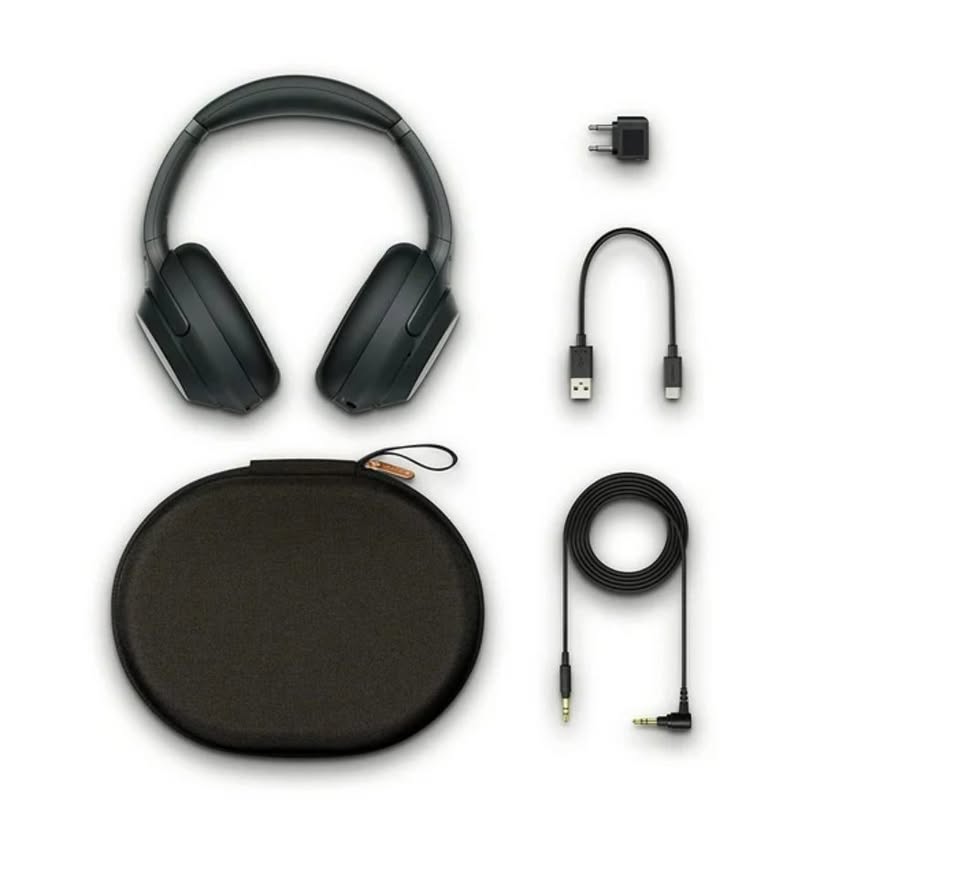 Black headphones with accessories including a carrying case, cable, and adapter