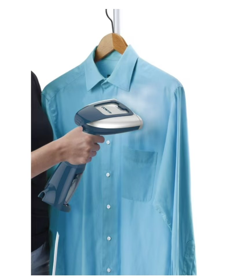 Person ironing a blue shirt on a hanger with a steam iron.