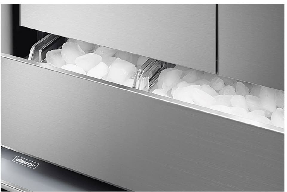 Stainless steel ice maker with ice cubes.