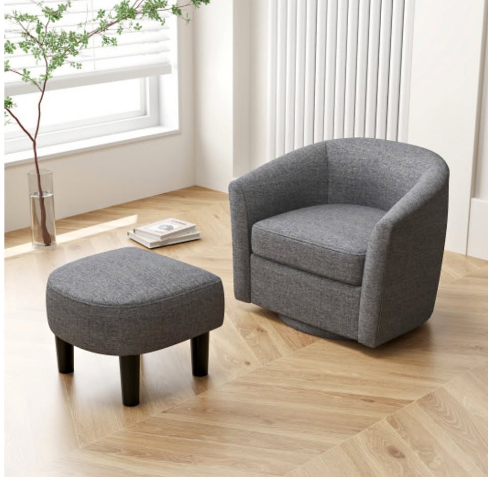 Gray armchair and ottoman set in a room with wooden floor.
