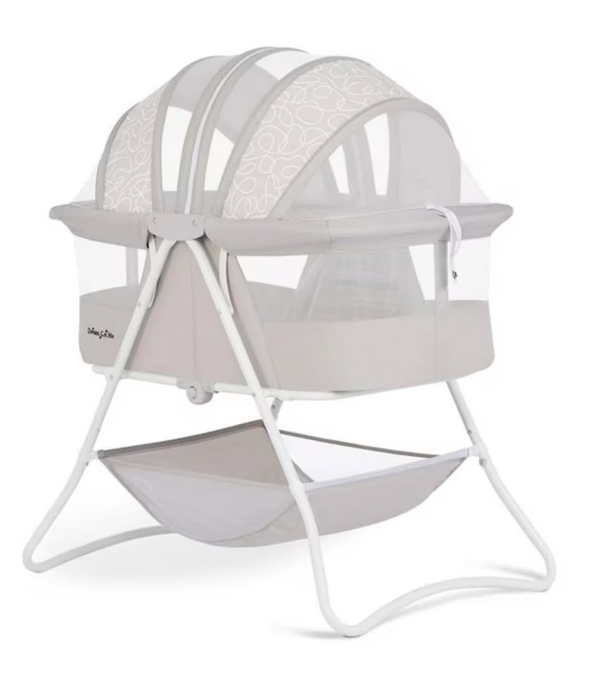 White baby bassinet with mesh hood on a white background