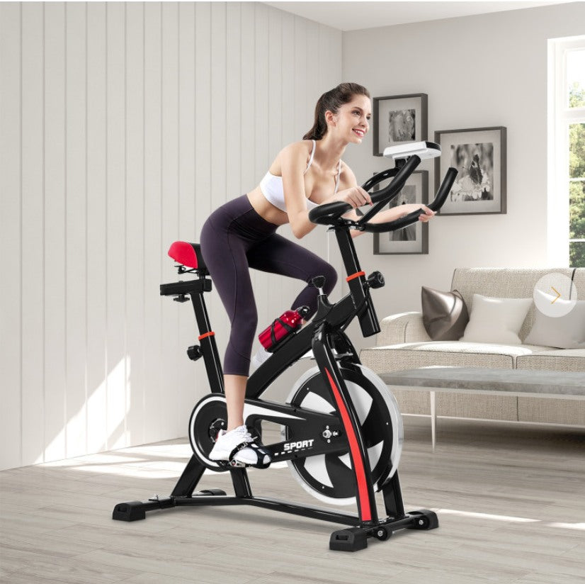 Woman exercising on a stationary bike in a living room.