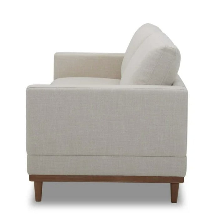 Beige armchair with wooden legs.