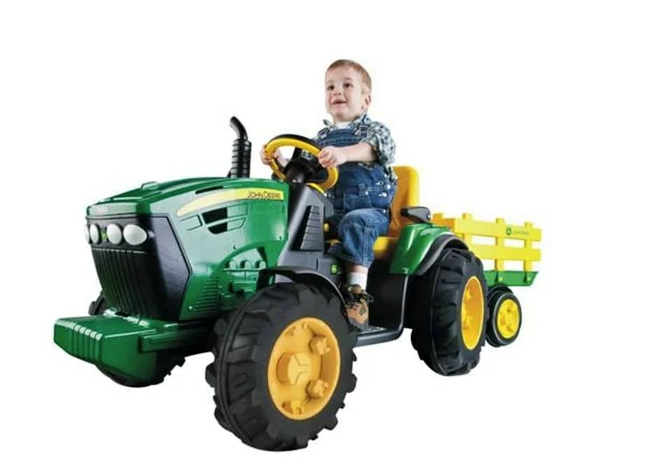 Child sitting on a toy tractor with a trailer